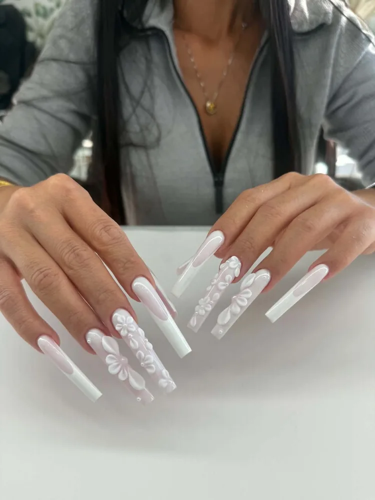 Extra-long square nails in milky white with sculpted 3D white flowers and pearl detailing