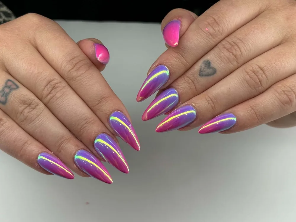 Long stiletto nails in a purple and hot pink holographic chrome finish